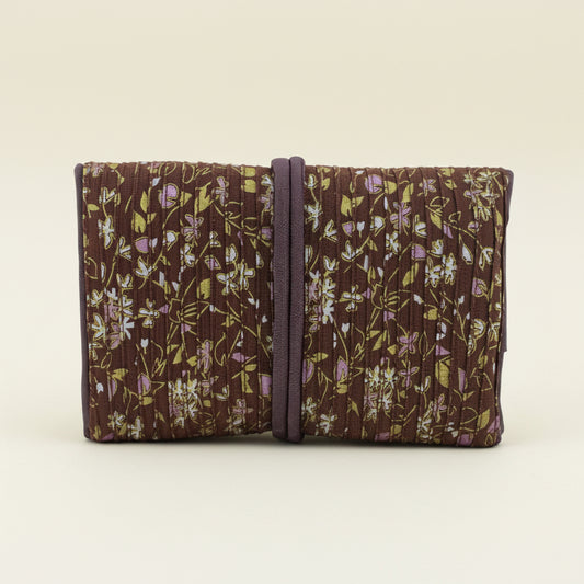 Floral fabric jewelry roll with dark tie strap, folded compartments