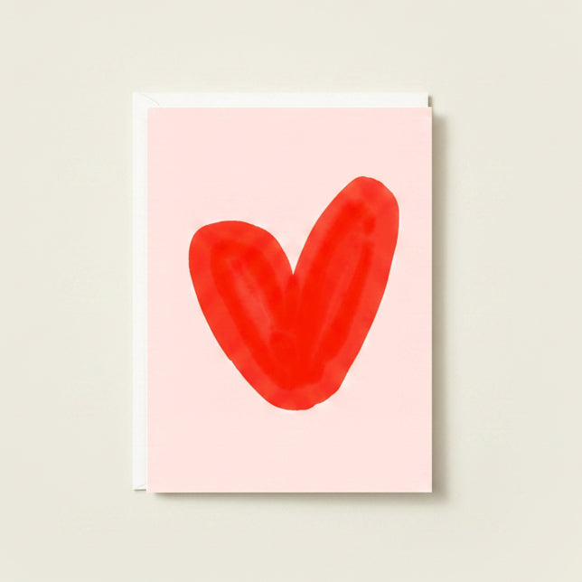 Red heart shape on a light pink background
