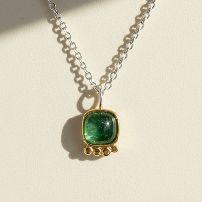 Silver chain necklace with green square gemstone pendant in gold bezel