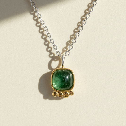 Silver chain necklace with green square gemstone pendant in gold bezel
