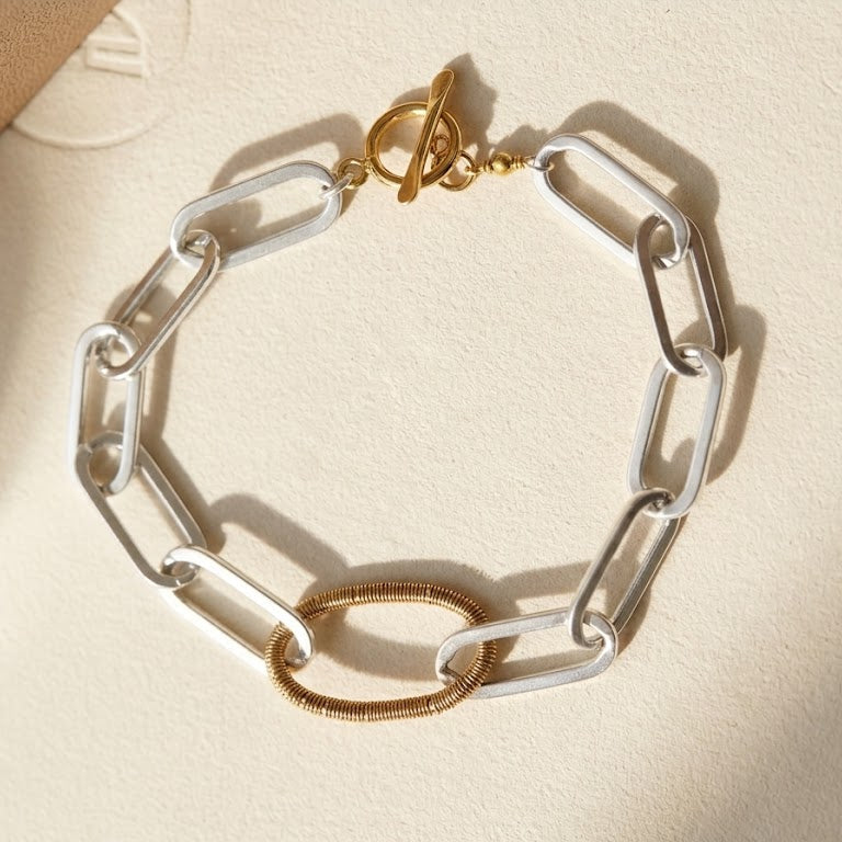 Two-tone paperclip link bracelet with gold clasp and silver oval spring detail
