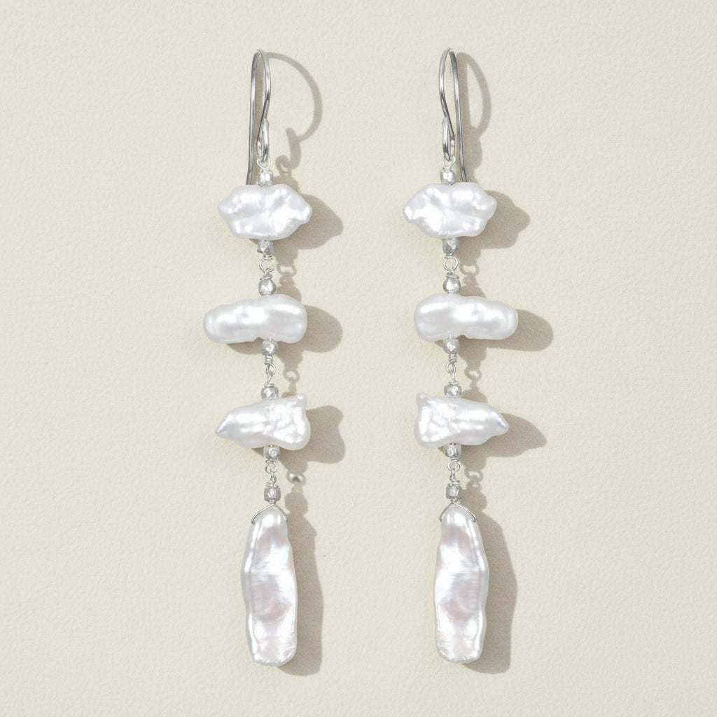 Pearl drop earrings on a beige background