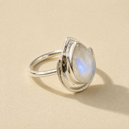Silver teardrop moonstone ring with blue iridescent stone set in curved bezel