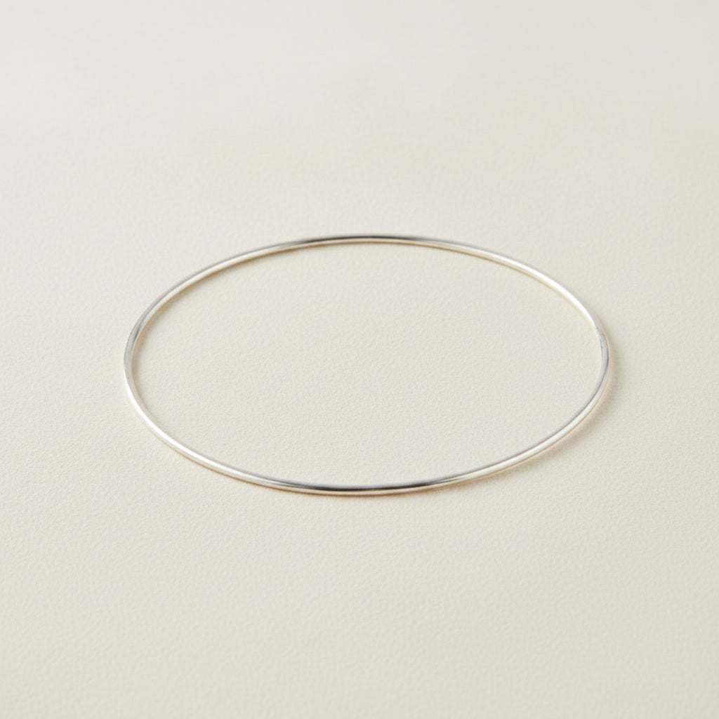 Silver-toned metal bangle bracelet with smooth oval shape