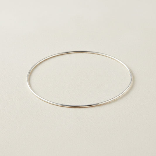 Silver-toned metal bangle bracelet with smooth oval shape