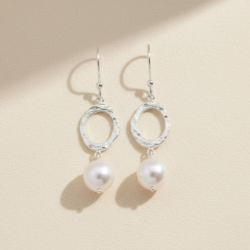 Silver hammered oval dangle earrings with white pearl drops