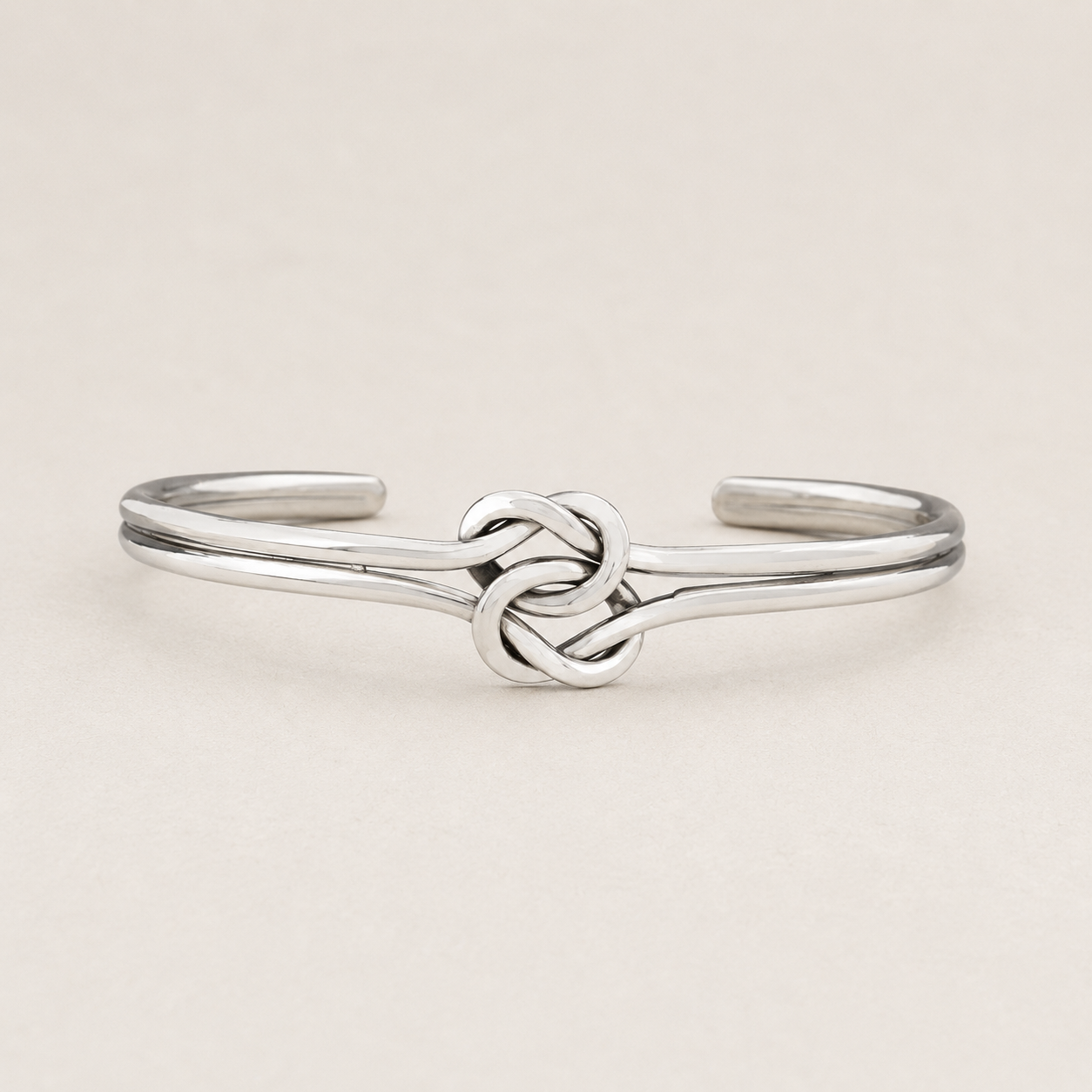 Silver cuff bracelet with double-knot chain centerpiece