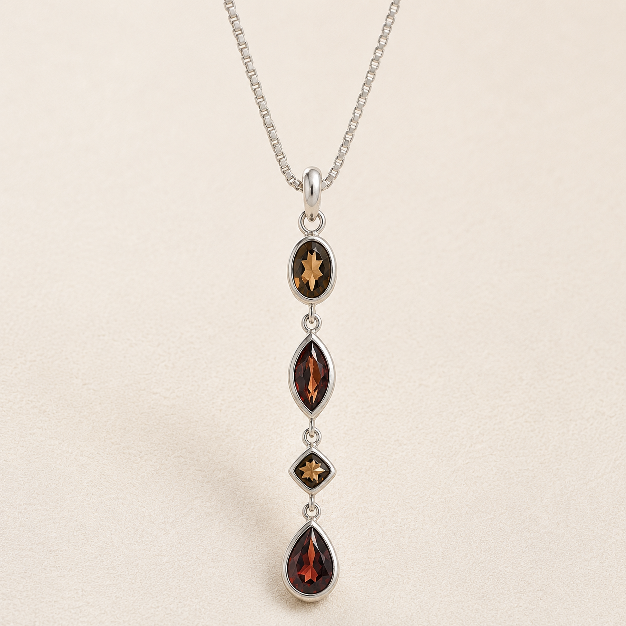 Gemstone drop necklace with four dark faceted marquise pendants and star accents