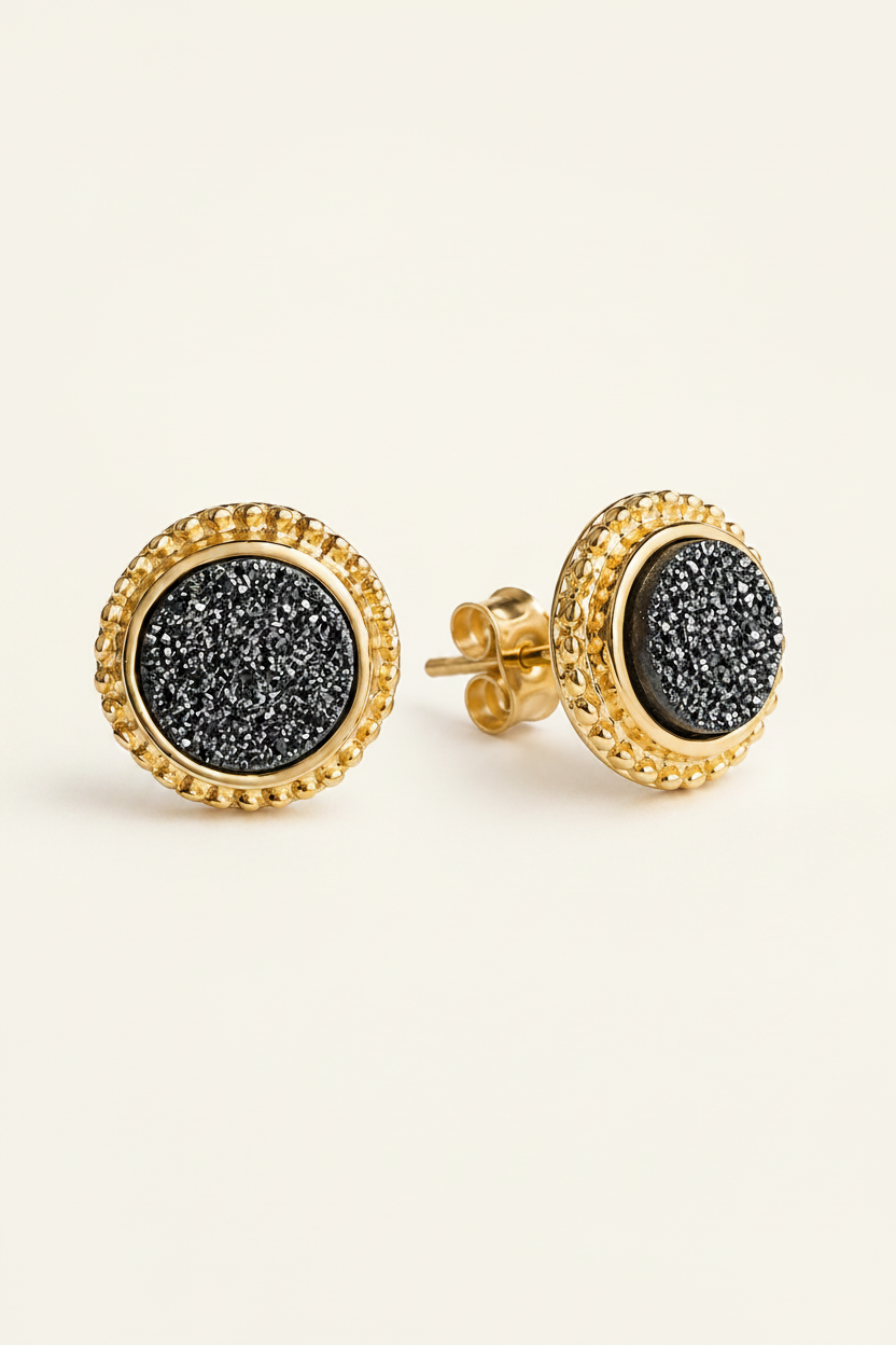 Gold earrings with black druzy stones on a white background