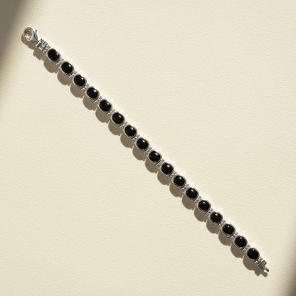 Silver bracelet with black oval cabochons and dark gemstone bar settings