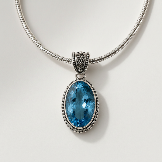 Silver snake-chain necklace with oval blue faceted filigree pendant