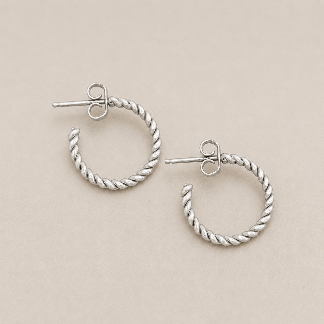 Twisted wire hoop earrings with twisted silver-tone hoops and heart stud posts