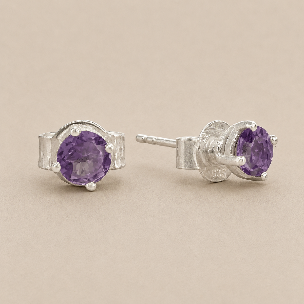 Silver prong-set amethyst stud earrings with purple oval gemstone and butterfly back