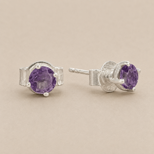 Silver prong-set amethyst stud earrings with purple oval gemstone and butterfly back