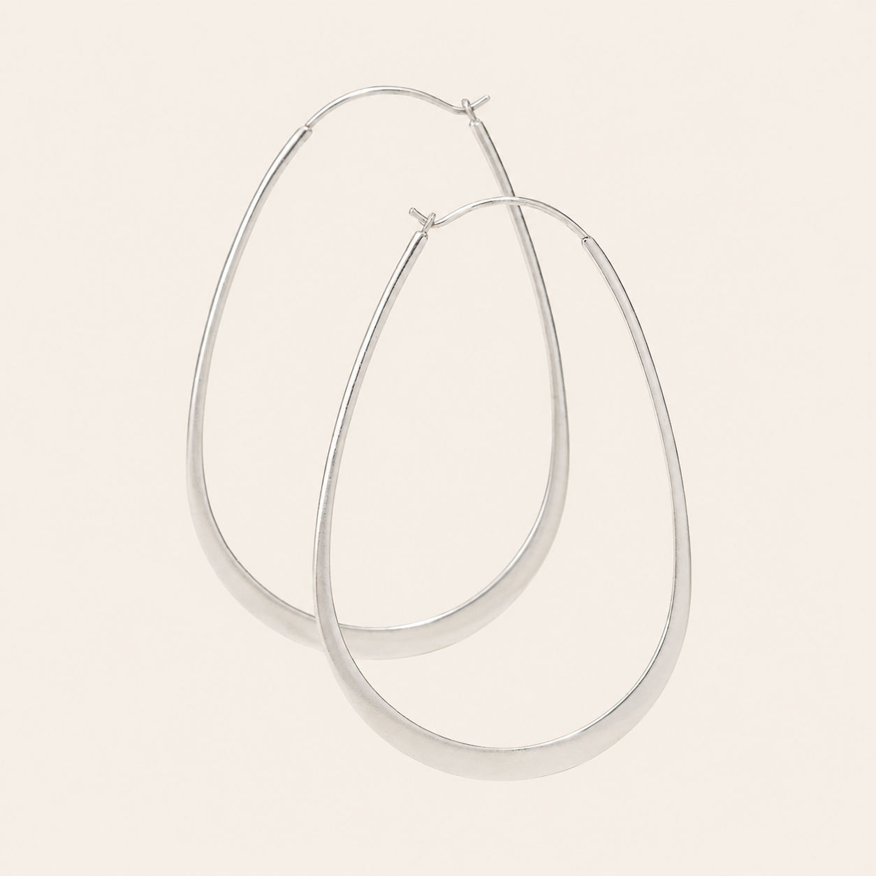 Flat oval hoop earrings, polished silver-tone metal, hinged closure at top