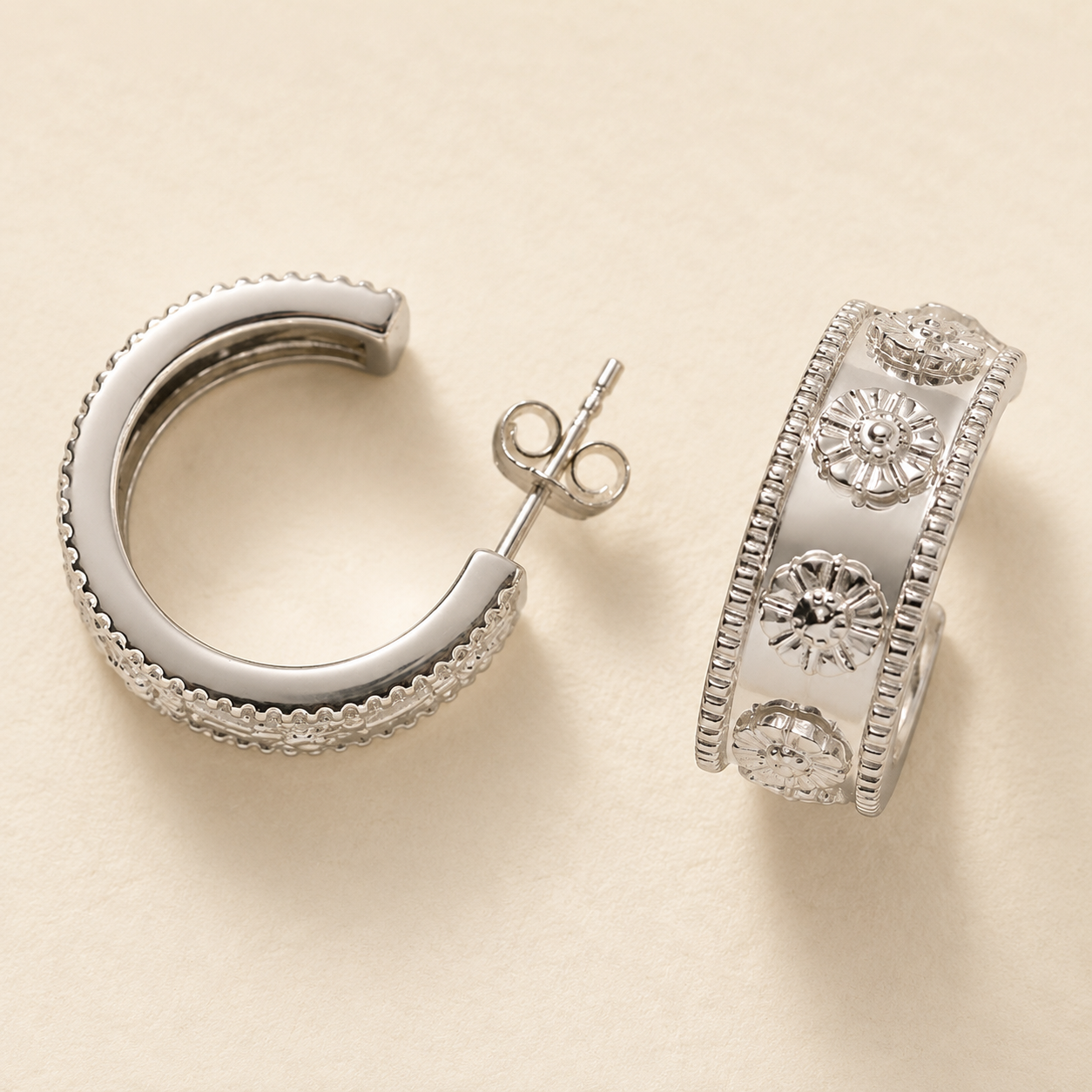 Silver-tone hoop earrings with textured edge and filigree floral detail