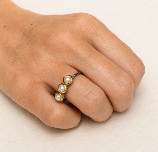 Gold-tone pearl ring with three white round pearls and dark textured band