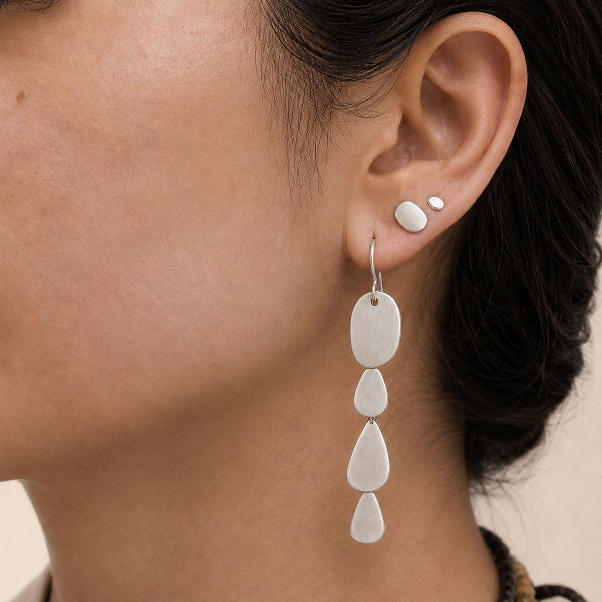 Silver-tone cascade earrings with three oval teardrop charms, side close-up