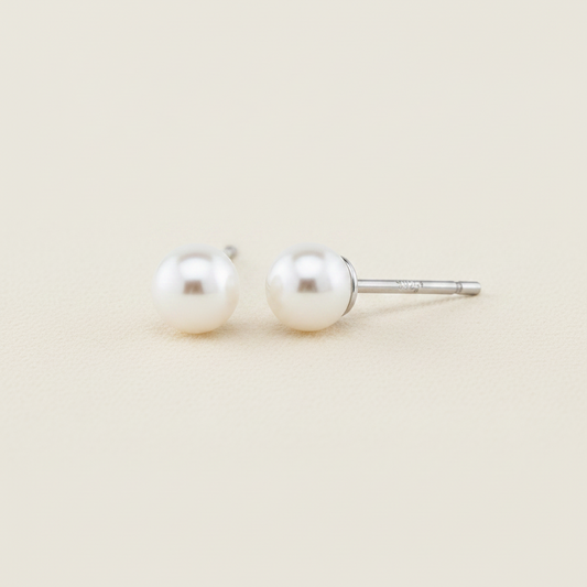 Large white pearl stud earrings with glossy round pearls on metal posts