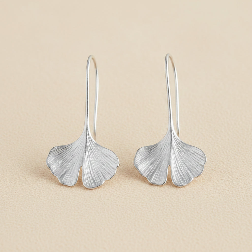 Silver ginkgo leaf drop earrings with curved leaf shapes and narrow hoop hooks.