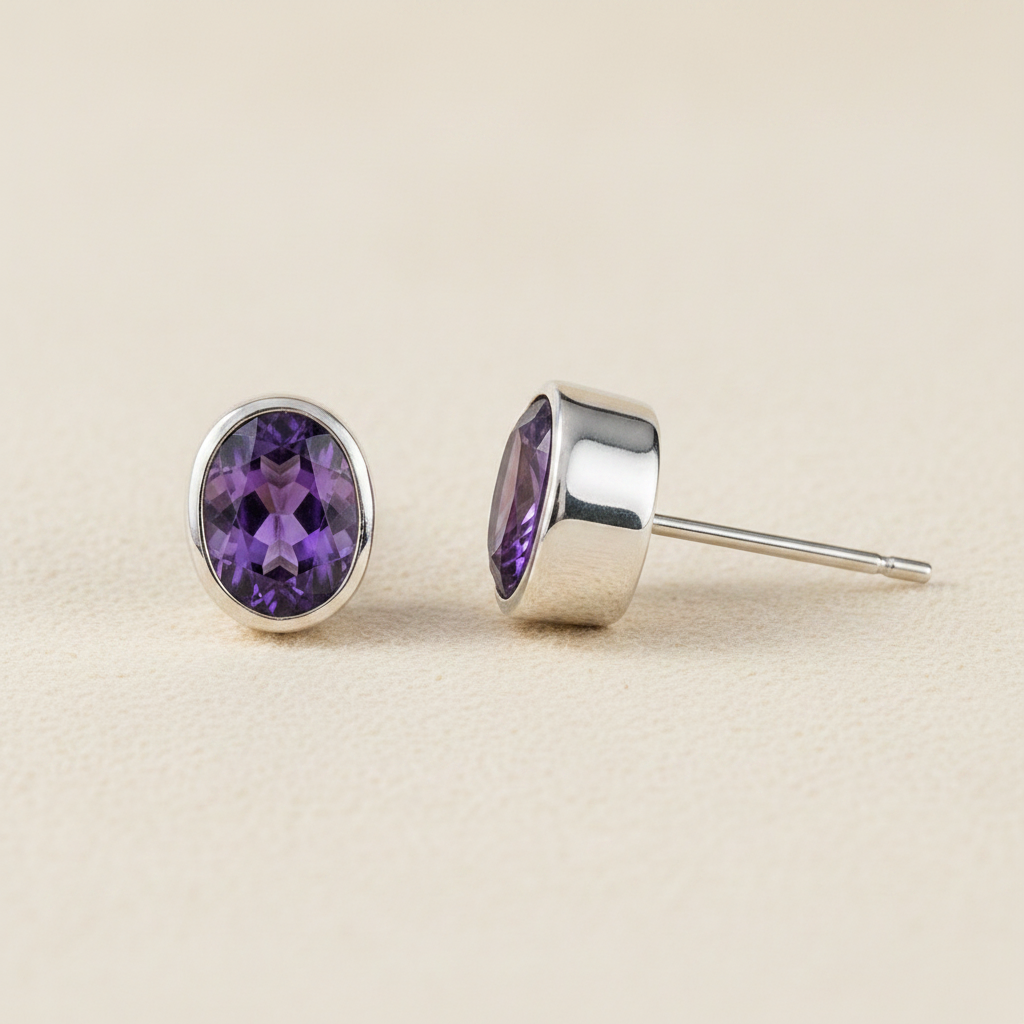 Oval amethyst purple gemstone stud earrings with silver bezel and post backing.