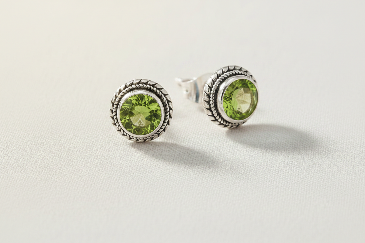 Silver gemstone stud earrings with rope-textured bezel and round peridot-green stones