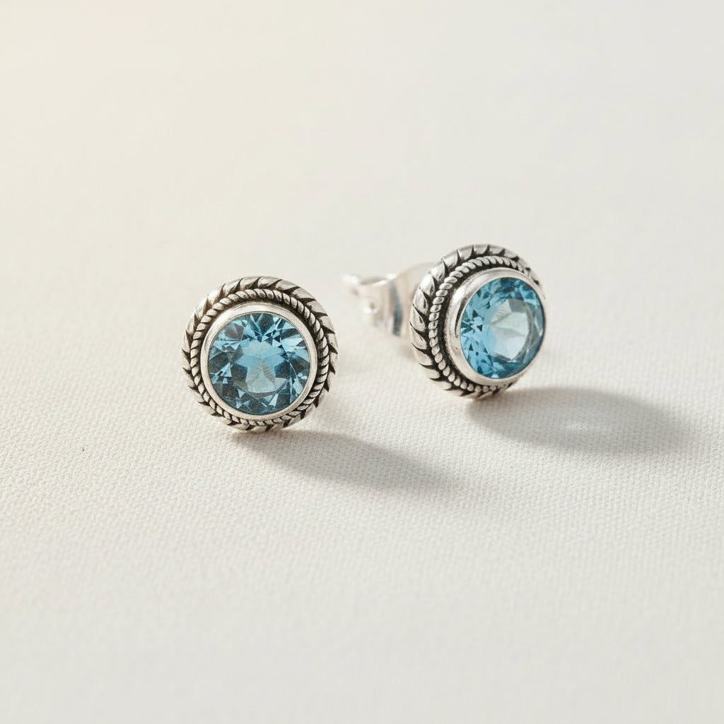 Sterling silver stud earrings with rope bezel and round blue topaz stones