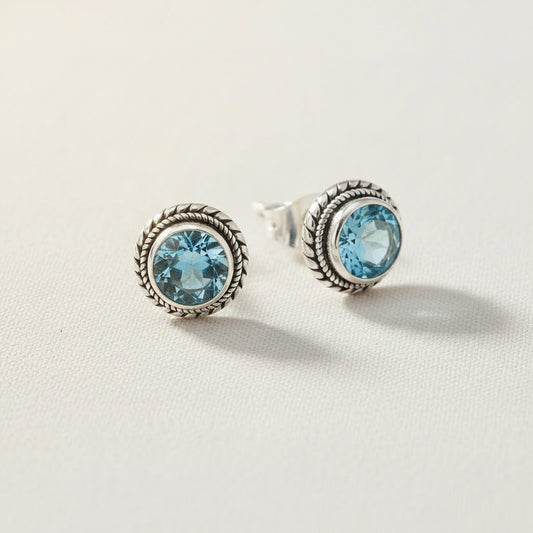 Sterling silver stud earrings with rope bezel and round blue topaz stones