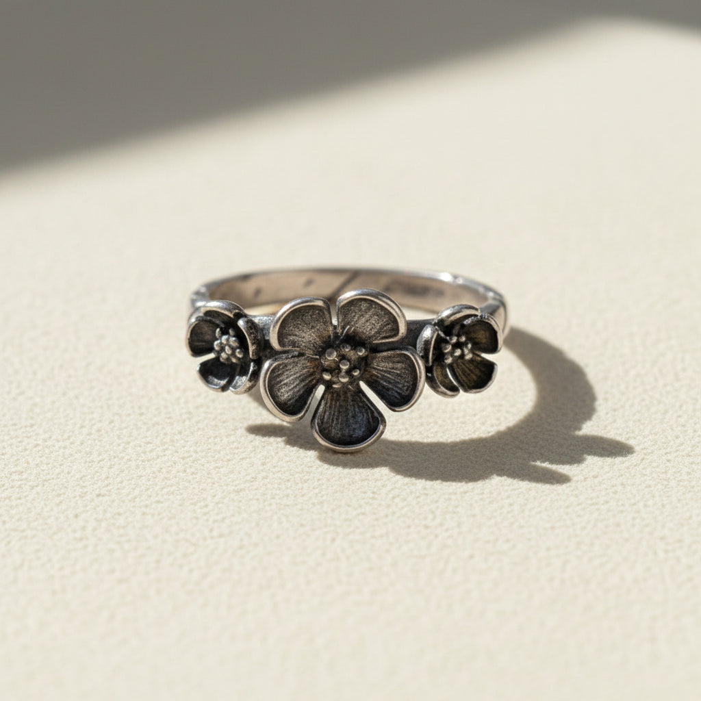 Silver flower ring with three bloom medallions on the band