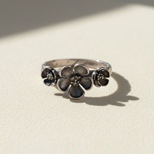 Silver flower ring with three bloom medallions on the band