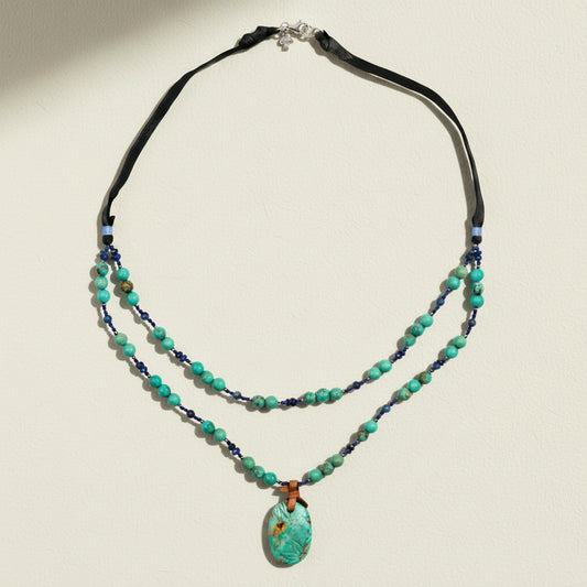 Necklace with turquoise beads and a pendant on a white background