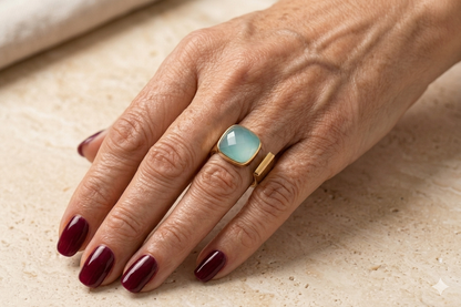 Gold-tone ring with square turquoise stone on finger, sleek band