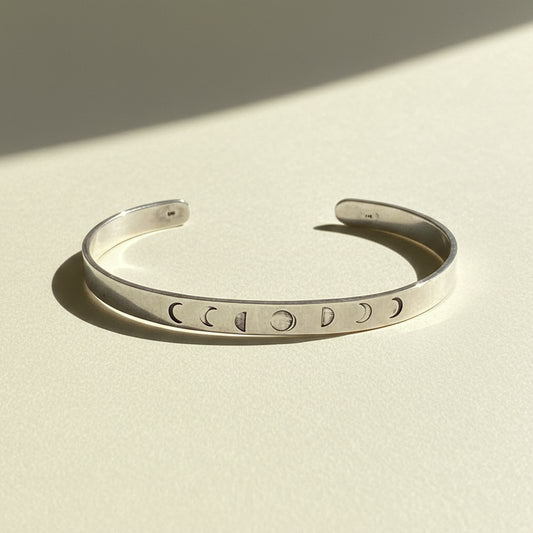 Silver cuff bracelet with moon phase cutout symbols