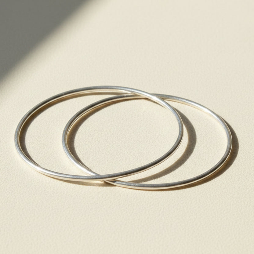 Pair of silver-tone infinite-loop bangle bracelets, overlapping open circles