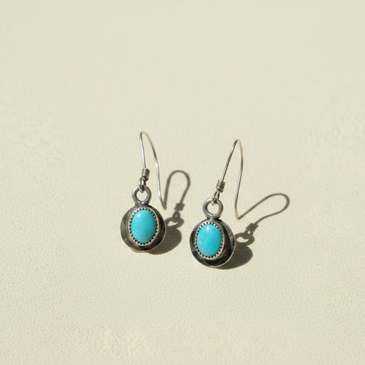 Turquoise oval drop earrings with dark metal bezel and fishhook backs