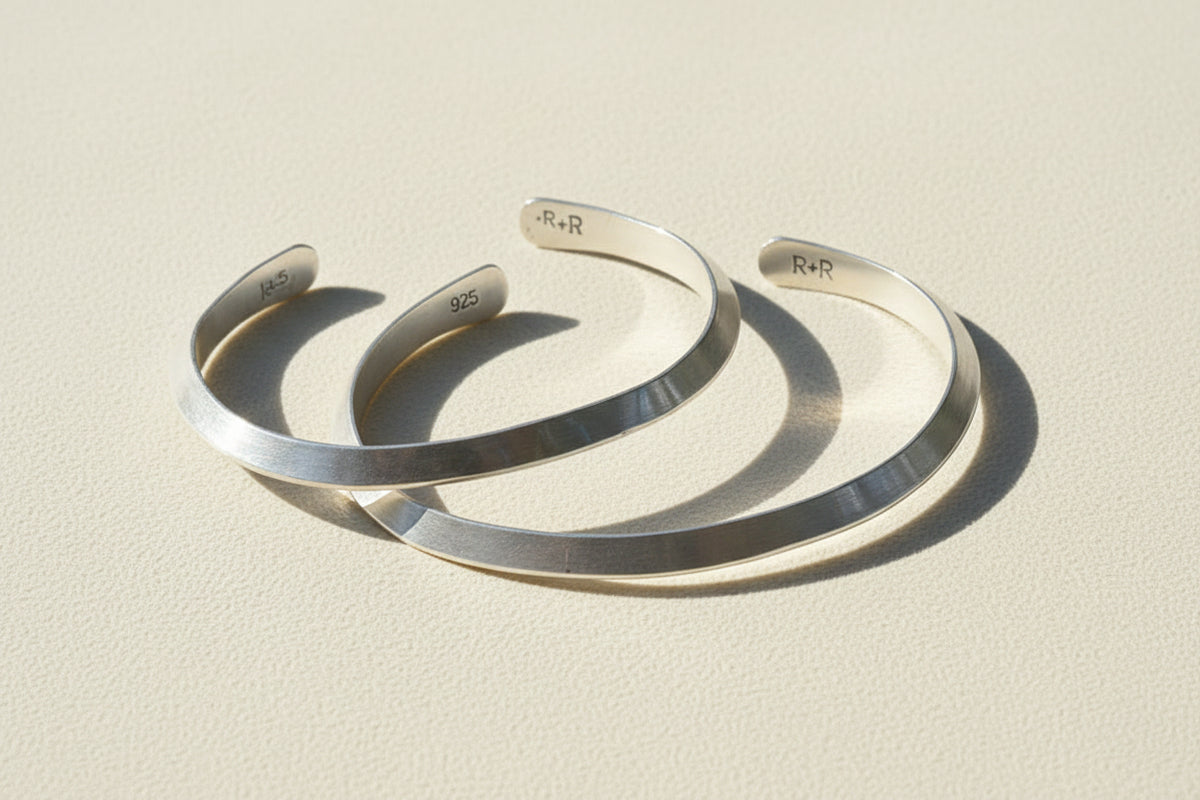 Silver cuff bracelet with engraved inner marking, open V-shaped profile