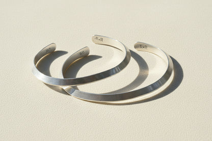 Silver cuff bracelet with engraved inner marking, open V-shaped profile