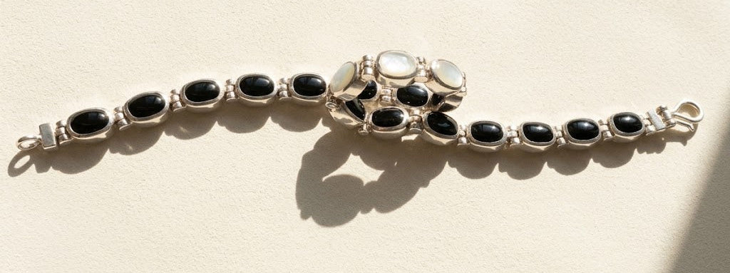 Silver bracelet with black oval cabochons in a linked row design