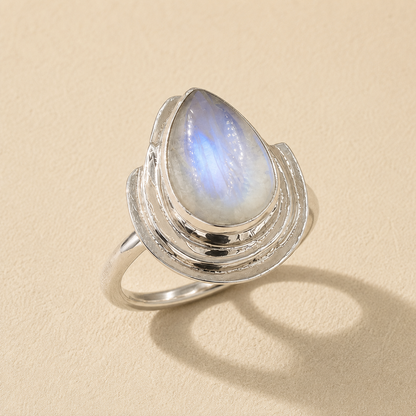 Silver teardrop moonstone ring with round blue iridescent glow on split band