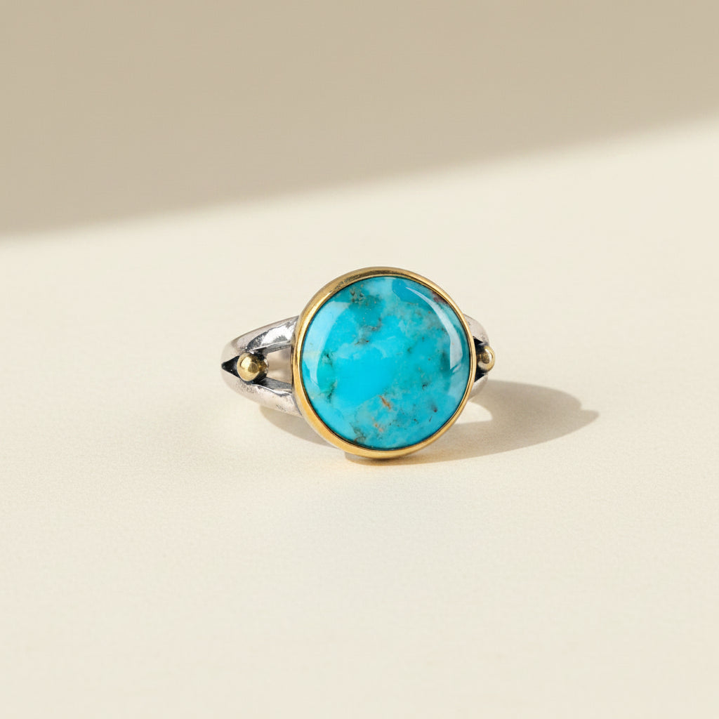 Turquoise oval gemstone ring with gold bezel and silver band, small side stones