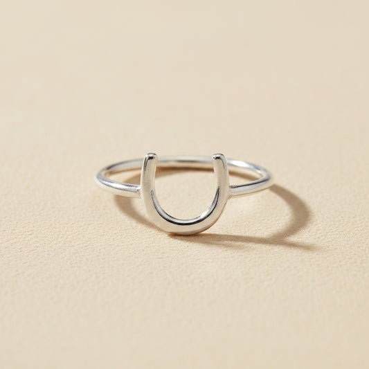 Silver horseshoe-shaped dainty ring with open U design on a slim band