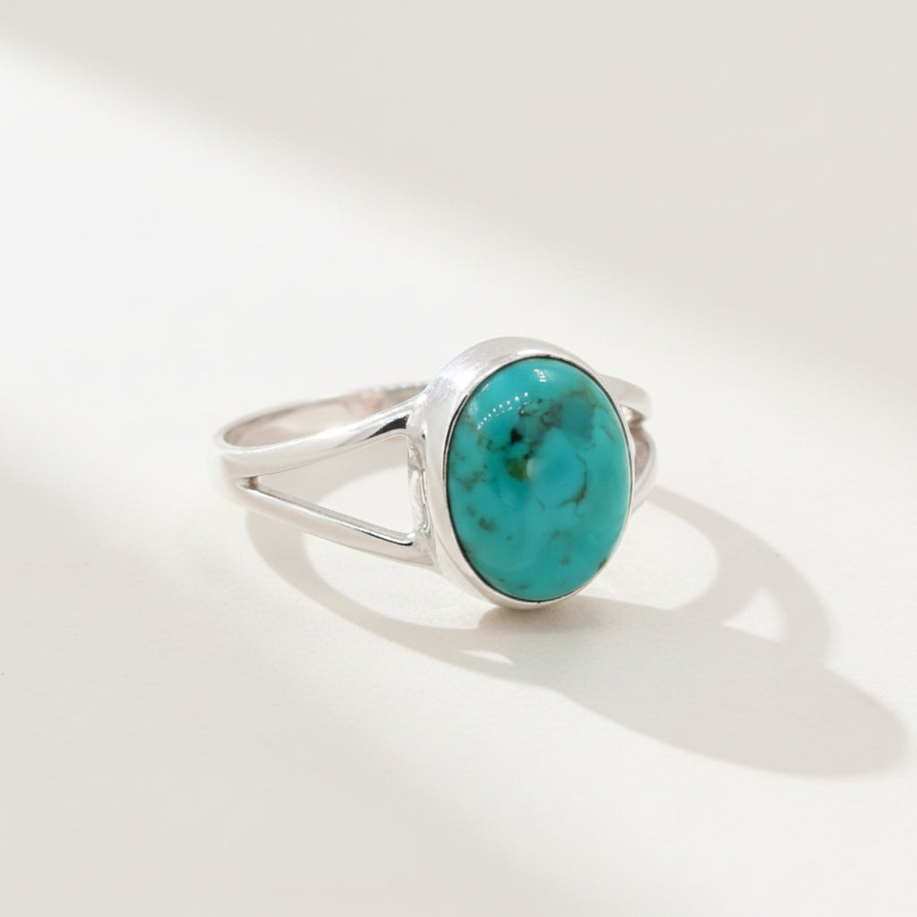 Silver ring with a turquoise stone on a white background