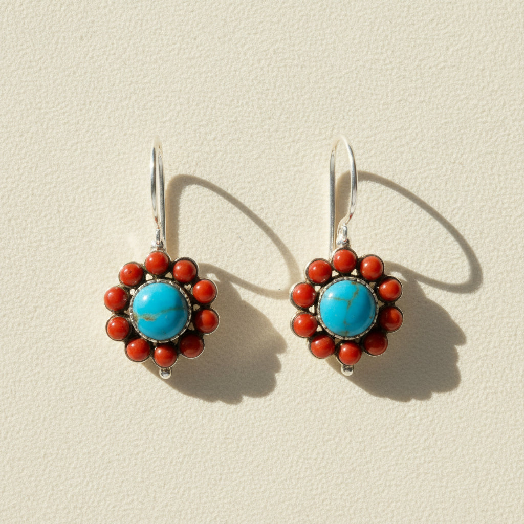 Pair of earrings with blue center and red accents on a white background