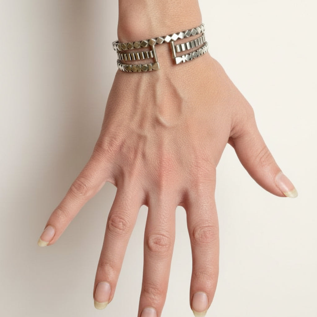 Striped silver cuff bracelet on wrist, stacked ridged bands with open end hardware