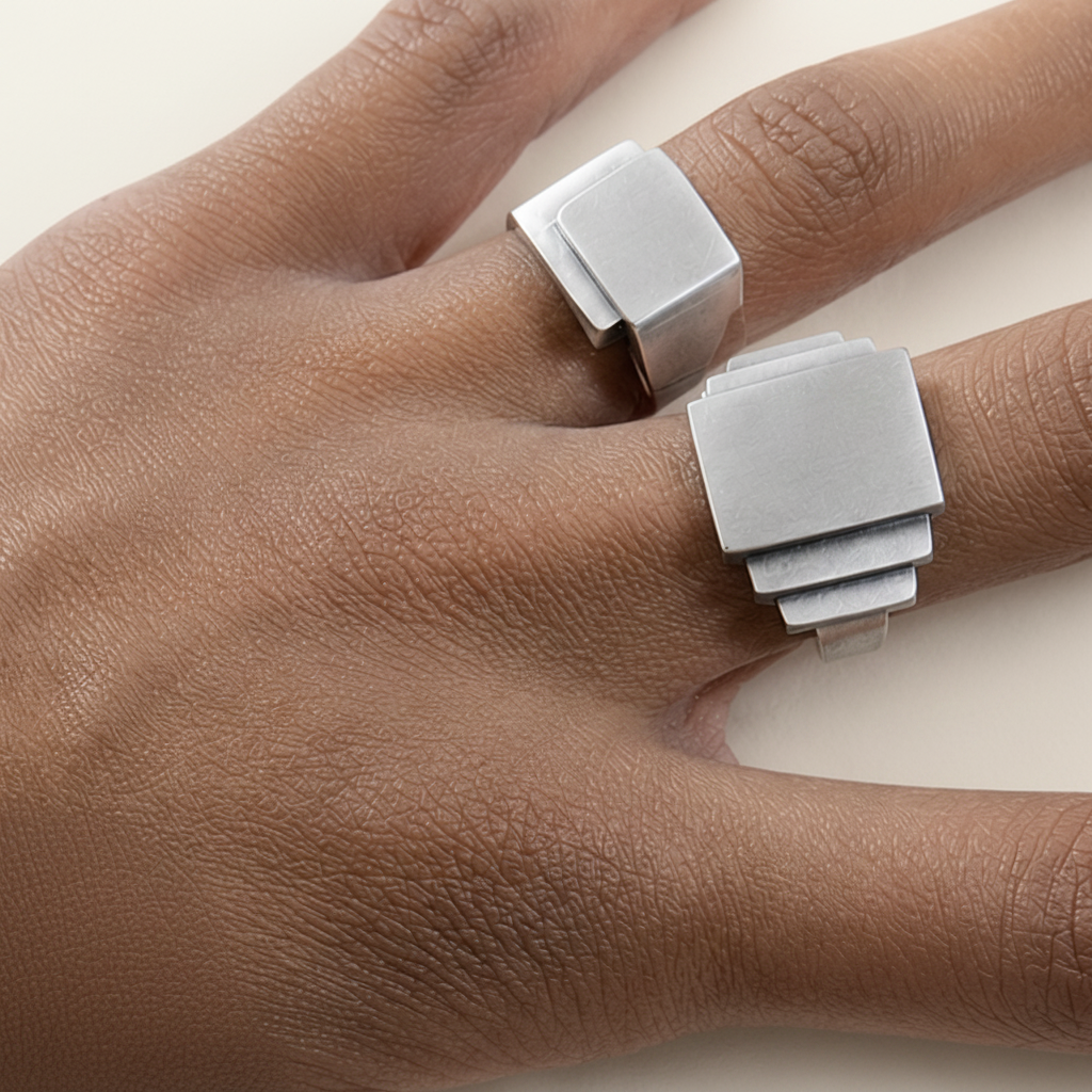 Silver-gray square fold-over deco ring worn on fingers, wide band with fold