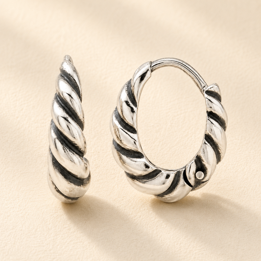 Silver twisted teardrop huggie hoop earrings with textured swirl design