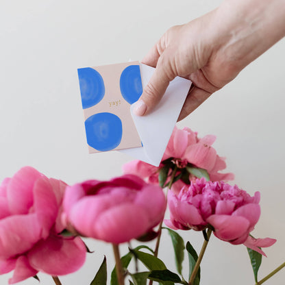 Blue dotted mini greeting card with 'yay!' text, held by hand