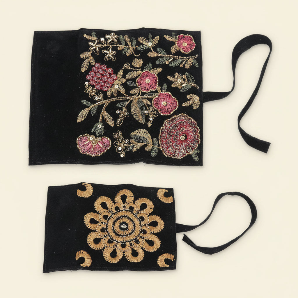 Black jewelry roll pouch with ornate gold and pink floral embroidery; tied string closure.