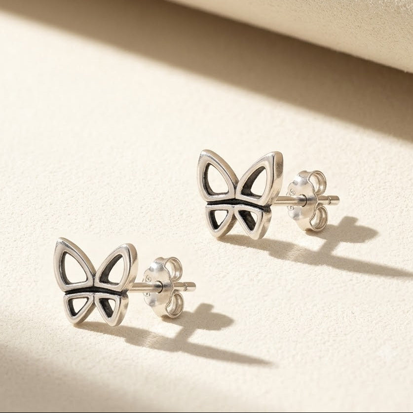 Butterfly stud earrings with silver-tone metal butterfly motif and butterfly cutout details