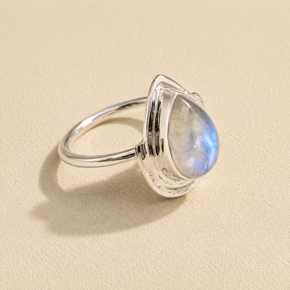 Silver teardrop moonstone ring showing blue glow on teardrop stone and slim band